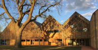 Feilden Clegg Bradley Studios nutzen Holz als wesentlichen Baustoff fr ihren Schulerweiterungsbau mit Spitzdchern in Sdengland. 
