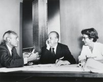 Phyllis Lambert 1955 mit Philipp Johnson und Ludwig Mies van der Rohe. Im Hintergrund: ein Modellfoto des Seagram Buildings 