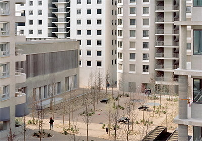 Das Apartmentgebäude B2 von AFAA mit Sozialwohnungen (links) und das Bürogebäude B6 von Christian Kerez mit einem klaren Stützen-Raster-System (rechts) bilden die Westfront des neuen Viertels. Dahinter ist der Wohnbau B5 von Herzog + de Meuron zu sehen.