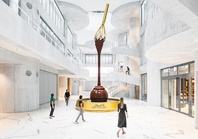 Ein schwungvoll gestaltetes Atrium ganz in Sichtbeton dominiert das Innere des Lindt Home of Chocolate.