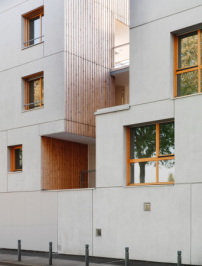 Die charakteristische Holzfassade wiederholt sich in den Kastenfenstern der  Betonfassade und schafft eine Verbindung zwischen dem Hofinneren und der Straßenseite (Paris, Alfortville) 