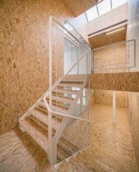 Im OSB-verkleideten Treppenhaus setzt weier Stahl Akzente. 