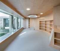 Hinter einer breiten Fensterwand im Erdgeschoss liegt die halbkreisfrmige Kinderbibliothek. 