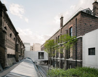 David Chipperfield Architects verbinden mit einem minimalistischen Brückengebäude aus Beton die Royal Academy mit einem ehemaligen Senatshaus  und schaffen aus beiden Bauten ein zusammenhängendes Ganzes.  
