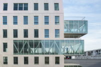 Bemerkenswert sind die gläsernen, auskragenden Plattformen, die der klaren Struktur des Gebäudes mit Büronutzung Raffinesse verleihen.  