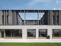 Das Sockelgeschoss aus beigem Klinker setzt sich kontrastreich vom Aufbau mit dunkler Holz-Glas-Fassade ab. 