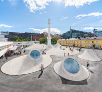 Oberlichter lassen JKMM Architects an einem zentralen Platz in Helsinki wie Augäpfel aus dem Boden ragen. 