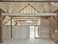 Die Dreiteilung des Großraums durch teils transparente Holzwände soll den ursprünglich vorgefundenen Dachraum spürbar machen.