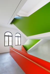 Im neuen Treppenhaus im östlichen Eckrisalit greifen Maedebach+Redeleit das Grün und Rot der historischen Fassade auf. 