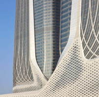 Die Fassade des unteren Gebäudesegments der Türme bespielen Zaha Hadid Architects mit Paneelen aus Textilbeton, die sie wie ein Gitter über den Bau spannen.  