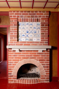 Der Kamin im Wohnzimmer musste weitgehend rekonstruiert werden, nur die Delfter Kacheln überstanden die Jahrzehnte unversehrt. 