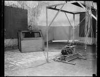 Das Gehör des Akustikers war bis 1930 wesentlicher Bestandteil der Versuchsanordnung – nicht aber sein Körper, der vom Hals an abwärts in einer Box isoliert wurde. Vivian L. Chrisler als „ Mann in der Kiste“ im Messraum des National Bureau of Standards, Washington, D.C., um 1930. 