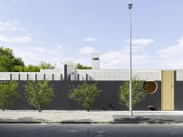 Zur Straße schützt eine schwarz gestrichene Betonmauer vor Blicken.  