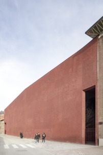 Die rote Backsteinwand zur Straße greift die historische Struktur des Beginenhofs auf, die schmale Öffnung ist der Haupteingang.  