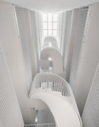 Jedes Gebäude wird über ein ausladendes, von oben natürlich belichtetes Atrium mit einer offenen Treppe erschlossen.