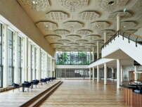 Das lichtdurchflutete Konzertfoyer von 1939. Alle Oberflächen wurden restauriert, die Traubenlüster an den ornamentalen Deckenrosetten sind rekonstruiert. 