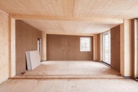 Das Holzskelett – aus Brettsperrholz-Elementen und Brettschichtholz-Decken – bleibt sichtbar. Die Ausfachungen werden innen mit Lehmputz versehen.  