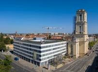 Kontrastreiches Duo: der wuchtige, wiederaufgebaute Kirchturm der Garnisonkirche neben dem „Kunst- und Kreativhaus Rechenzentrum“ in Potsdam, 2023 