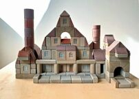 Steinbaukasten Bauhütte, Fuchs & Beug, DE (Bayern) 1920er und 1950er Jahre: Der Steinbaukasten steht in der Tradition der Anker-Baukästen, die ab 1884 produziert wurden. Die Elemente solcher Kästen sind aus verschiedenen Naturprodukten zusammengesetzt und fühlen sich daher an wie echter Stein.