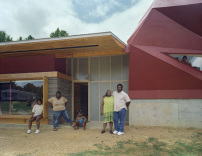 Rural Studio: Lucy Harris mit Familie vor ihrem neuen Haus in Masons Bend, Alabama, 2002 entworfen, organisiert und (teilweise) gebaut von Studenten des Rural Studio 